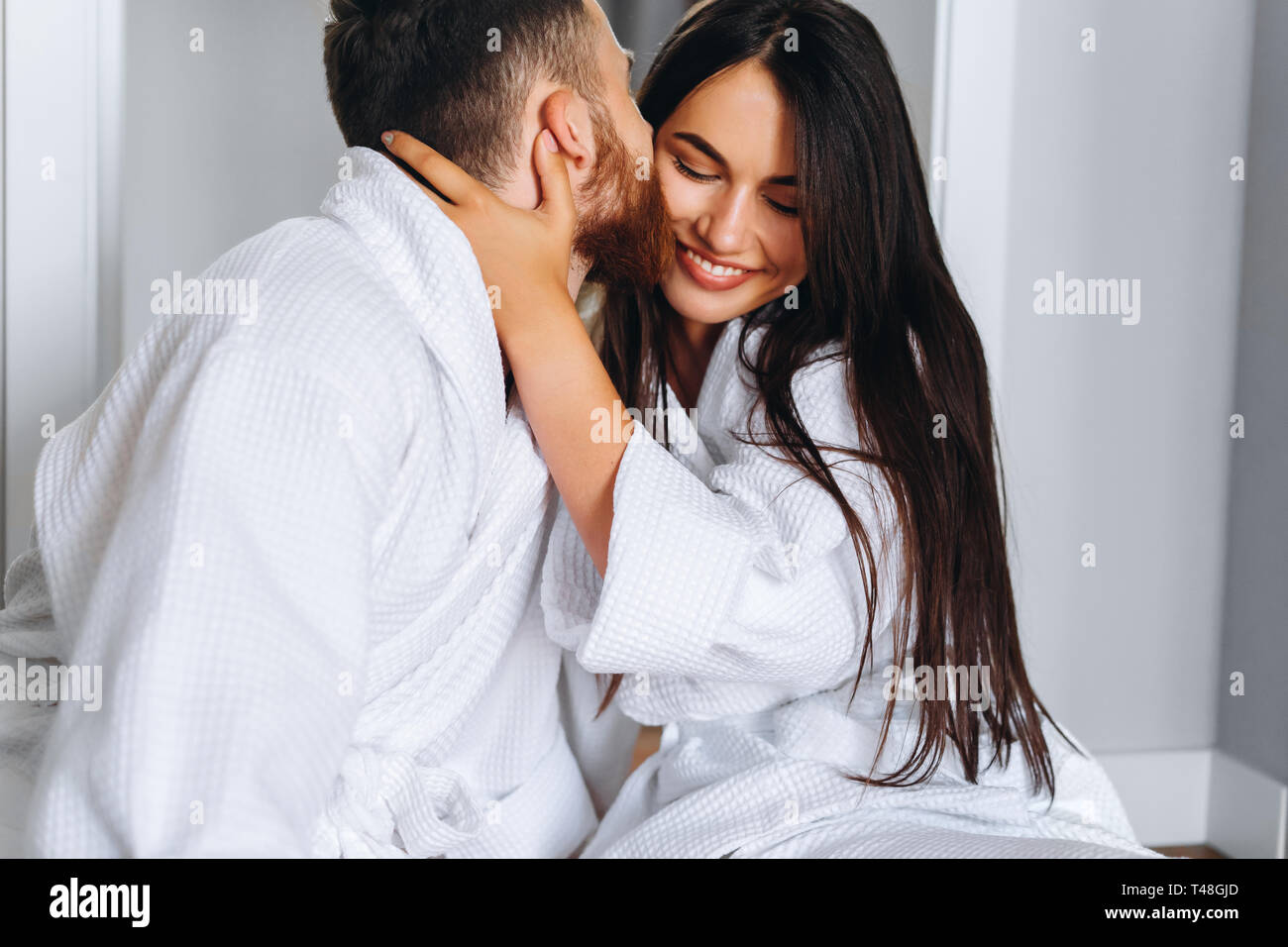 Handsome Man Kissing Beautiful Woman On Cheek While In Bed At