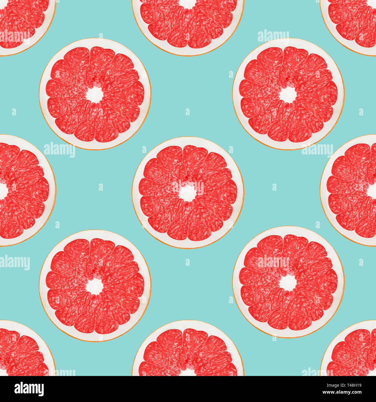 Grapefruit seamless pattern Big pink grapefruit halves on a light blue background Stock Photo