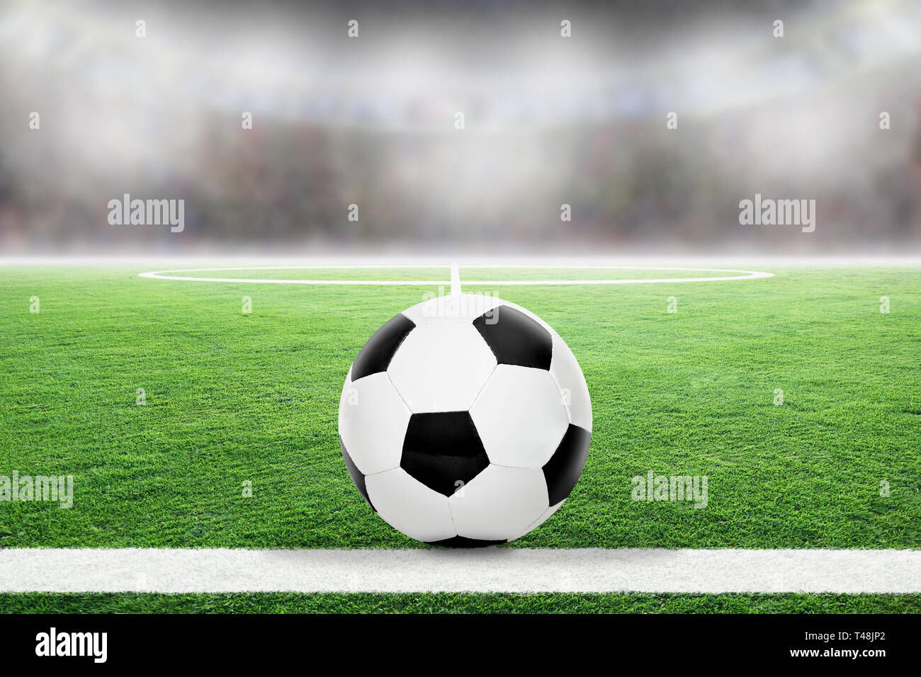 Soccer on football stadium field with blurred crowd background and copy