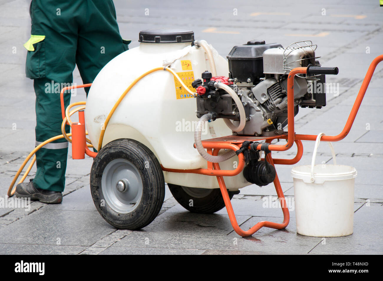 Watercart on wheels, portable watering system on pedestrian street, close up Stock Photo
