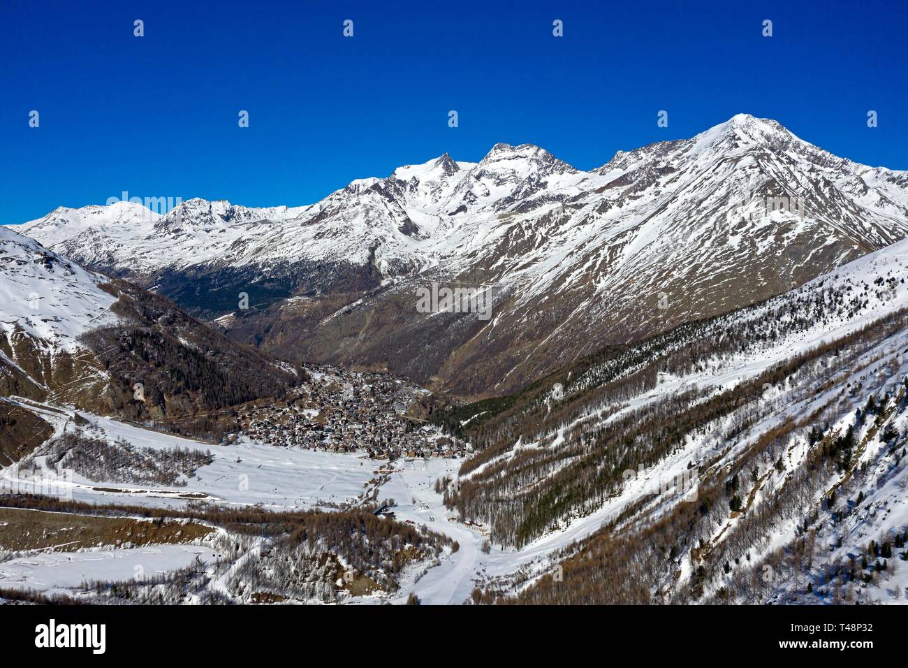 Saas-Fee in the valley, Fletschhorn, Lagginhorn and Weismies peaks at the back, mountain landscape in winter, Valais, Switzerland Stock Photo