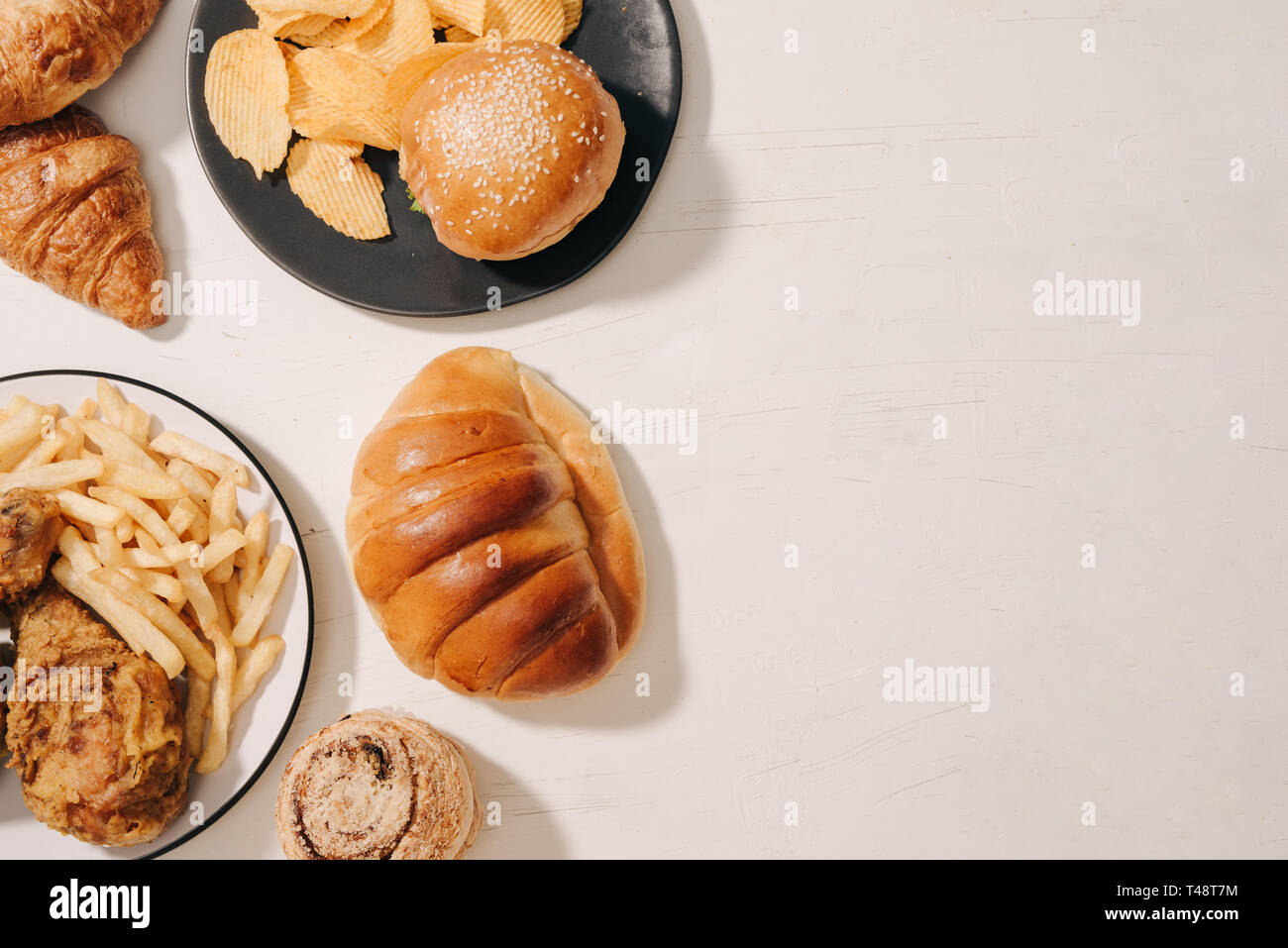 fast food and unhealthy eating concept - close up of fast food snacks and cola drink on white table Stock Photo