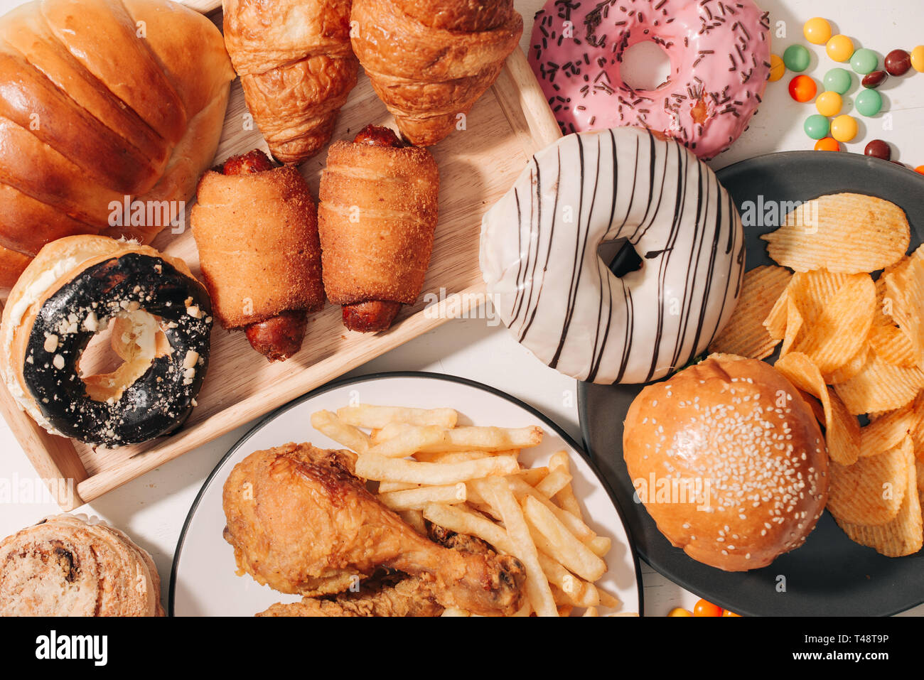 fast food and unhealthy eating concept - close up of fast food snacks and cola drink on white table Stock Photo