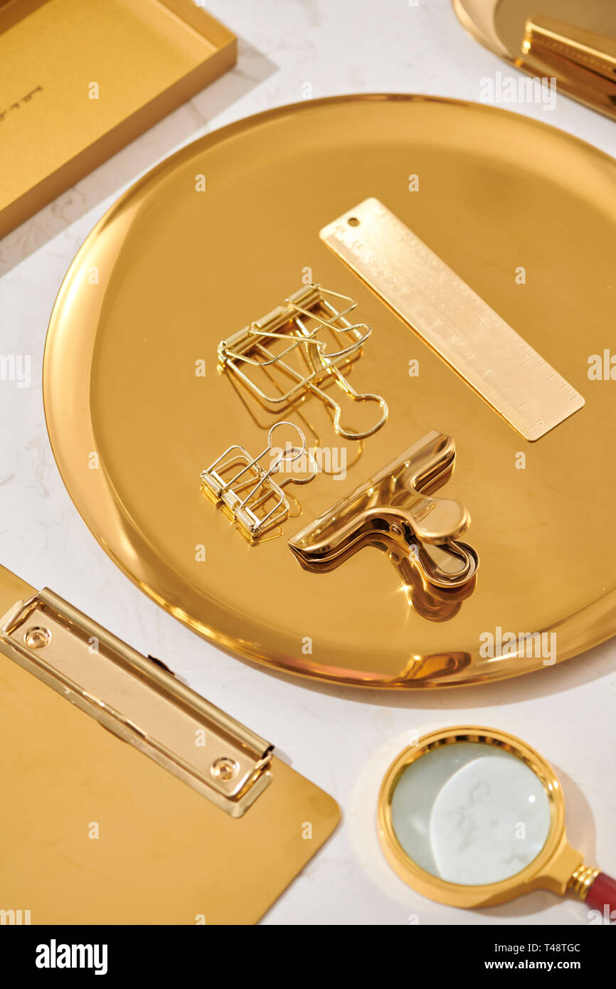 Gold items. Flat lay. Accessories on the table, woman desk top. View top table, background mock up. Envelope top Stock Photo