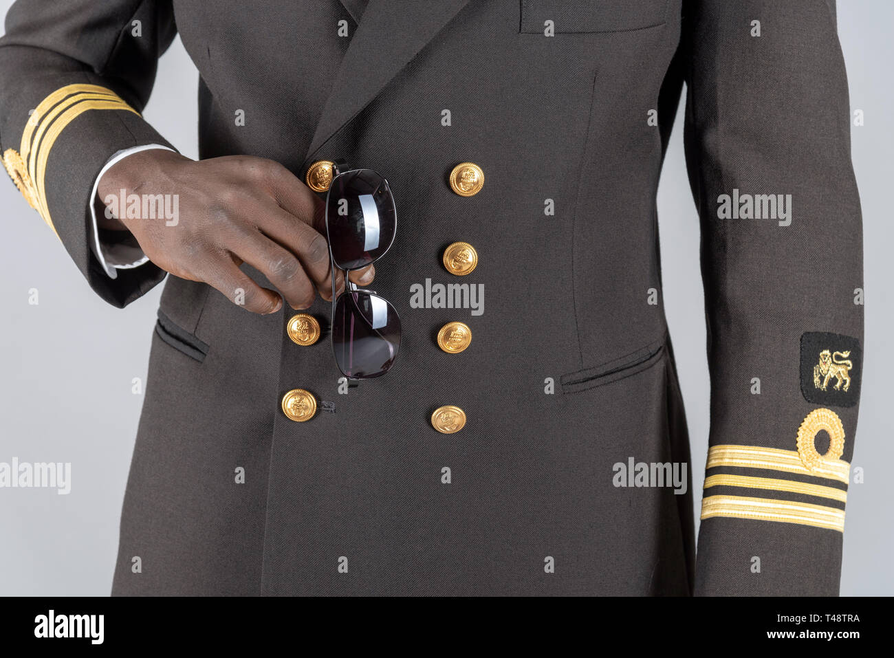 Lieutenant Commander wearing uniform of the South African Navy. Holding a pair of sunglasses. Stock Photo