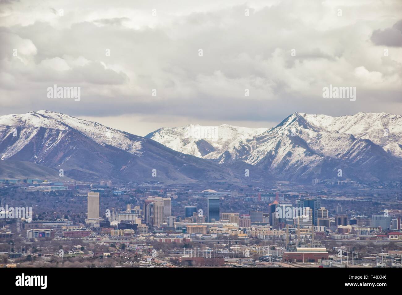 Downtown Salt Lake City Panoramic view of Wasatch Front Rocky Mountains from airplane in early spring winter with melting snow and cloudscape. Utah, U Stock Photo
