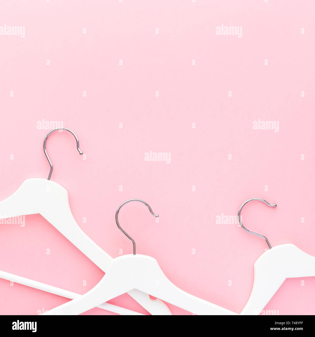 Creative top view flat lay white wooden hangers pastel millennial pink ...