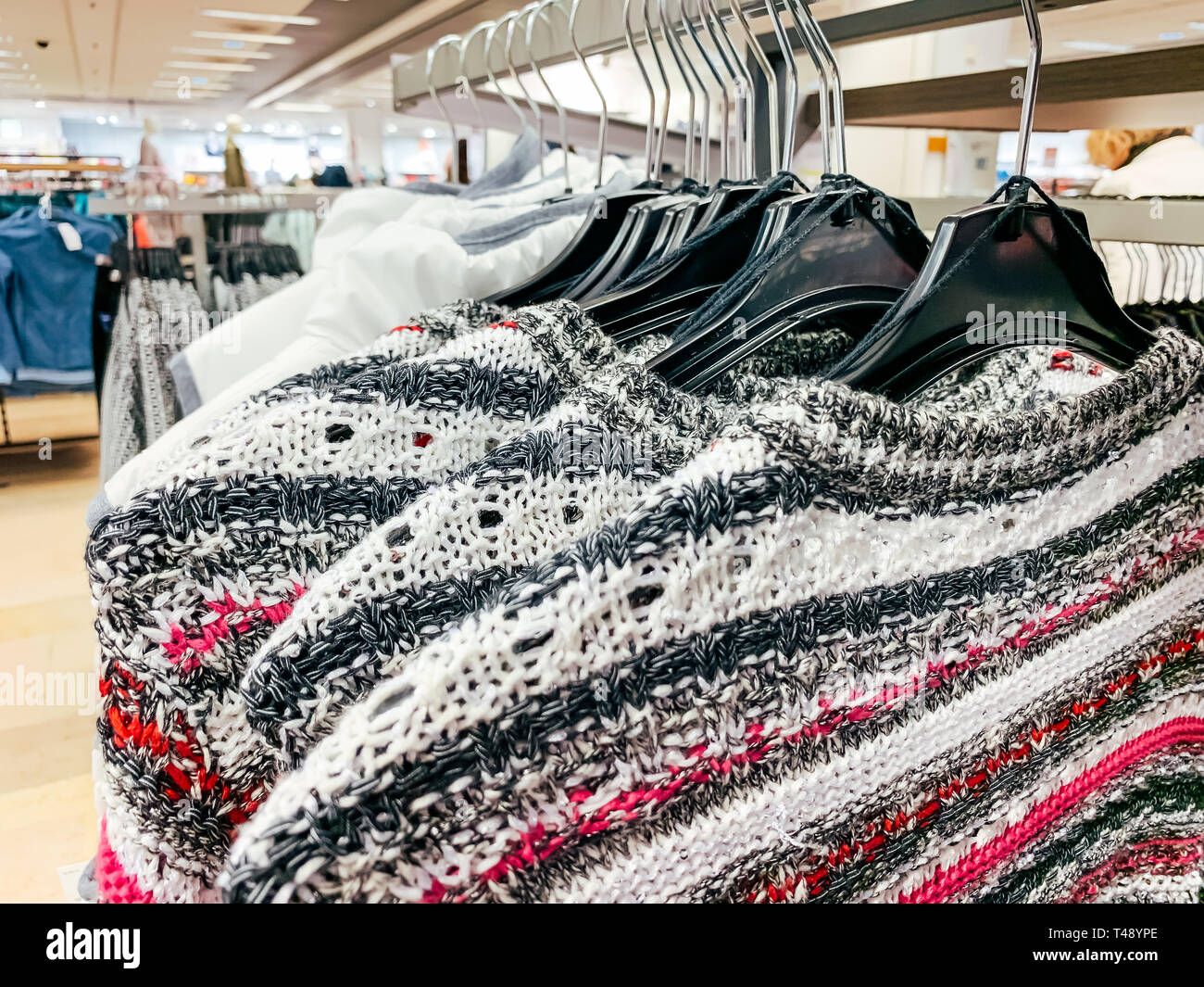 Female Clothes on racks at a Fashion Store. Mobile photo Stock Photo ...