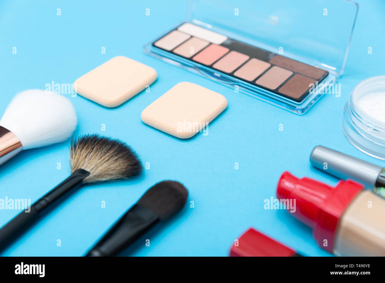 Decorative cosmetics, makeup products and brushes on blue background Stock Photo