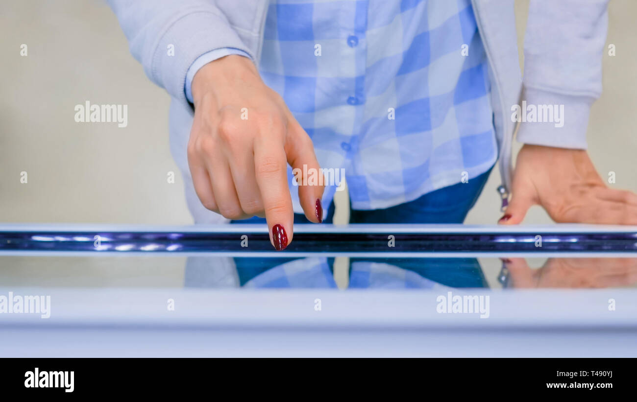 Woman using interactive touchscreen display kiosk Stock Photo