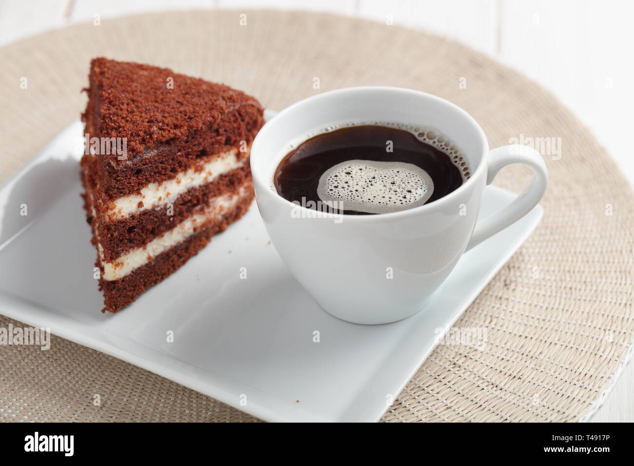 Chocolate sour cream cake and a cup of black coffee Stock Photo