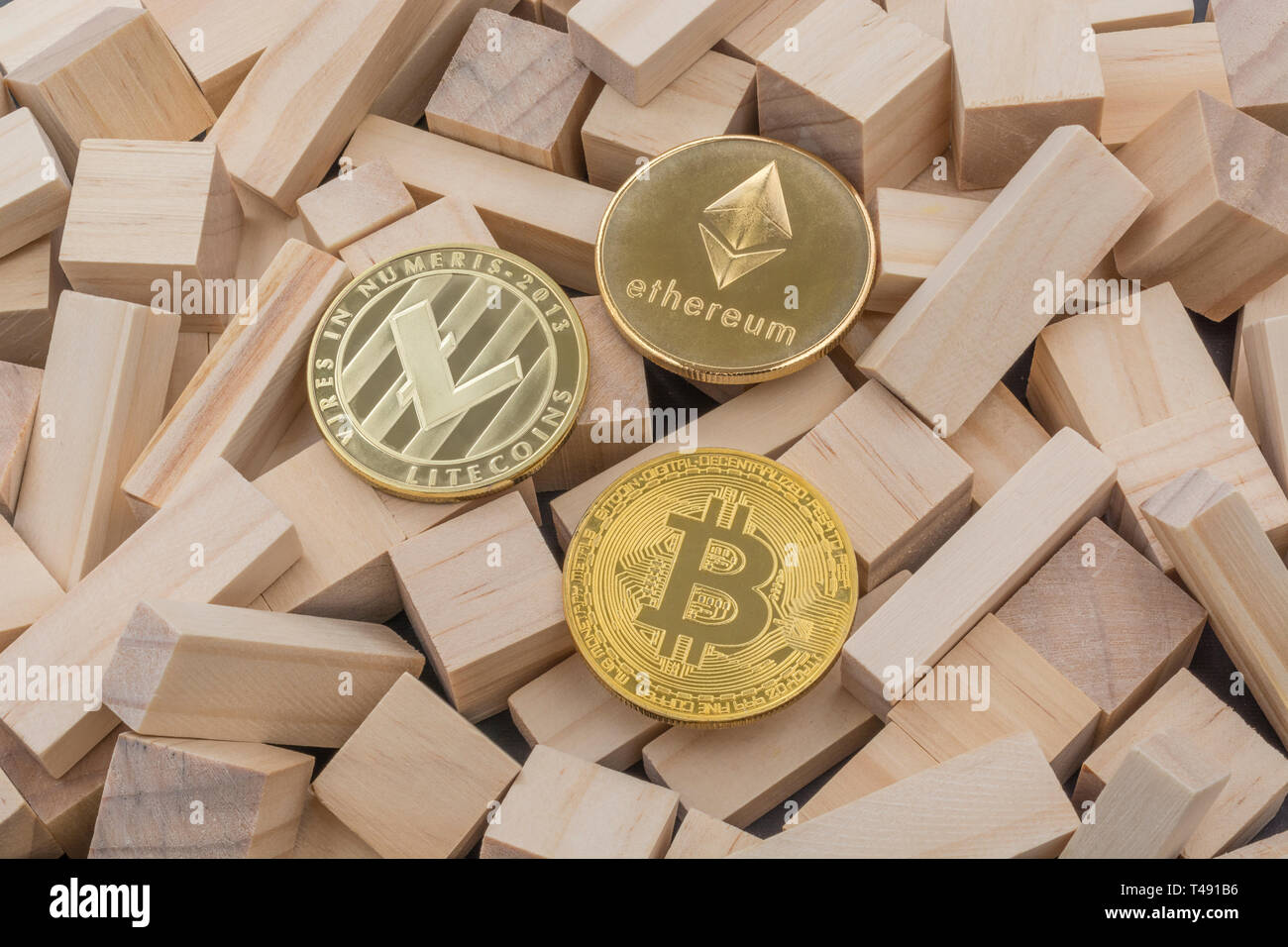 Ethereum, Litecoin, Bitcoin tokens on small wooden bricks. For FTX cryptocurrency crash, Bitcoin crash Litecoin crash Ethereum crash, SVB bank crash. Stock Photo