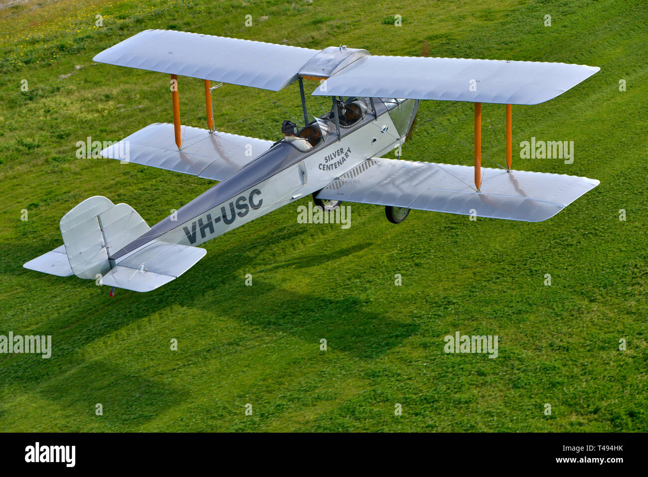 Aerial view of the one and only Silver Centenary biplane landing on grass strip, from Western Australia. Flown by the original builders grandson. Stock Photo