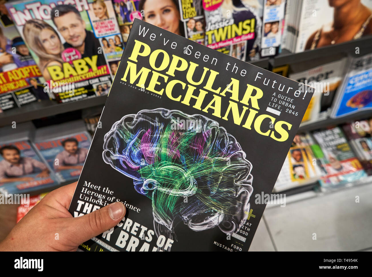 MONTREAL, CANADA - OCTOBER 9, 2018: Popular Mechanics magazine in a hand over a stack of magazines. Popular Mechanics is a magazine of popular science Stock Photo