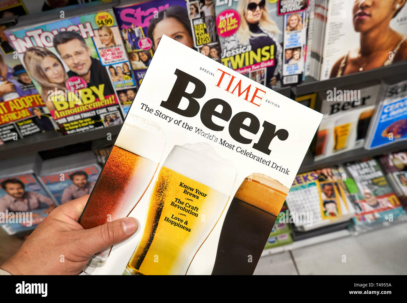 MONTREAL, CANADA - OCTOBER 9, 2018: Time magazine, special edition dedicated to Beer as the most celebrated drink in a hand over a stack of magazines. Stock Photo