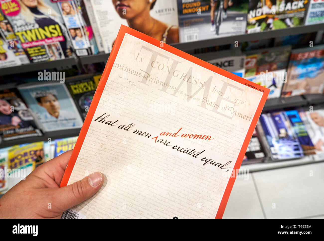 MONTREAL, CANADA - OCTOBER 9, 2018: Time magazine with The United States Declaration of Independence on the front cover in a hand over a stack of maga Stock Photo