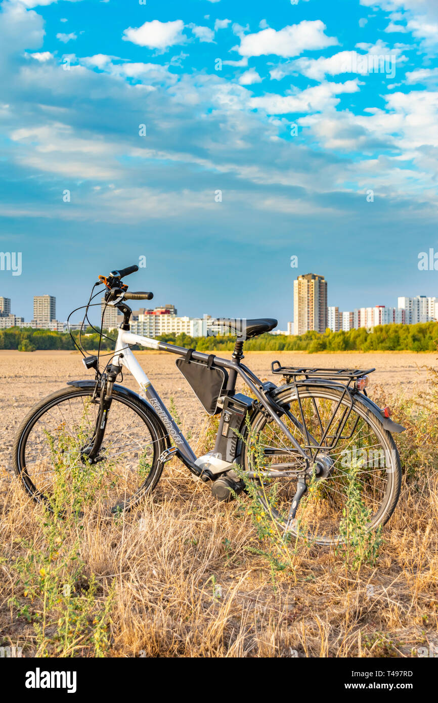 Berlin, Germany - September 12, 2018: Pedelec standing near a field. In the background you can see the satellite town Gropiusstadt in Berlin-Neukölln. Stock Photo