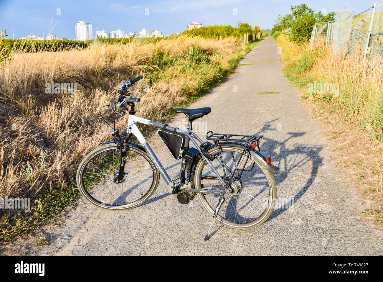 Berlin, Germany - September 12, 2018: Bicycle standing on a path. In the background you can see the satellite town Gropiusstadt in Berlin-Neukölln. Stock Photo