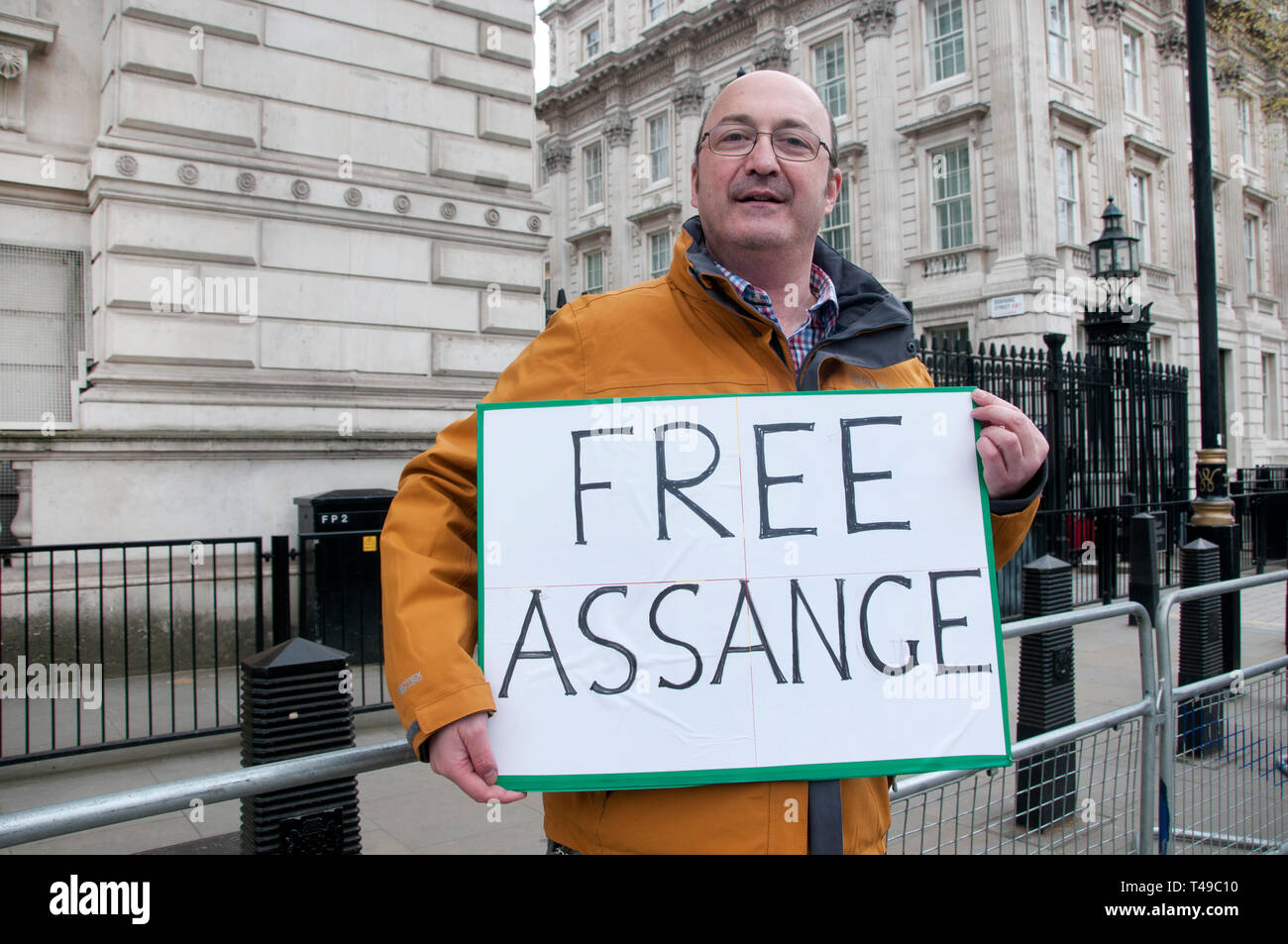 Whitehall, Downing Street.  A lone protester holds a placard saying 'Free Assange', the day after Julian Assange was arrested in the Ecuadorian Embass Stock Photo