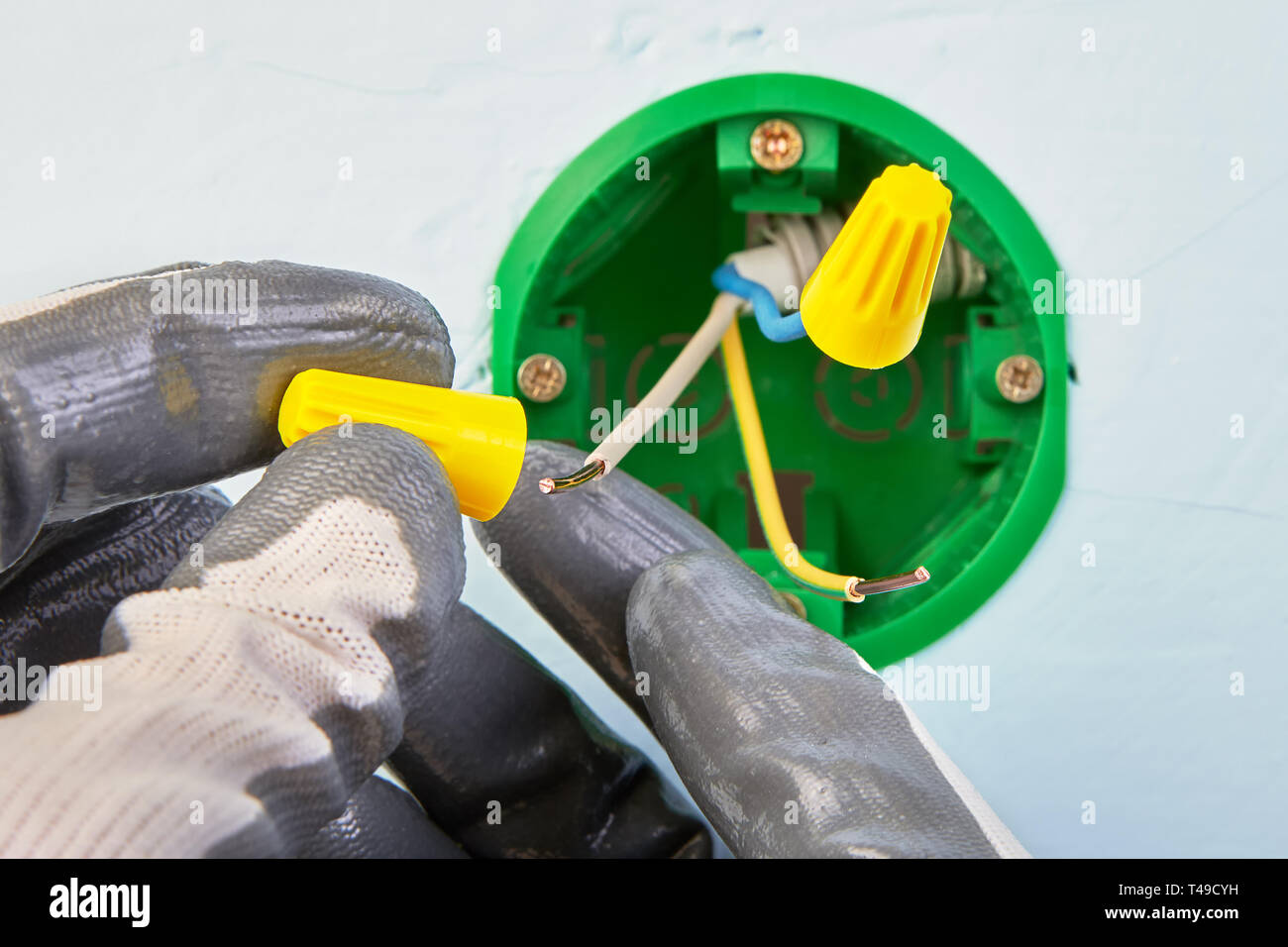 Worker in protective gloves is putting electrical conductors on wires