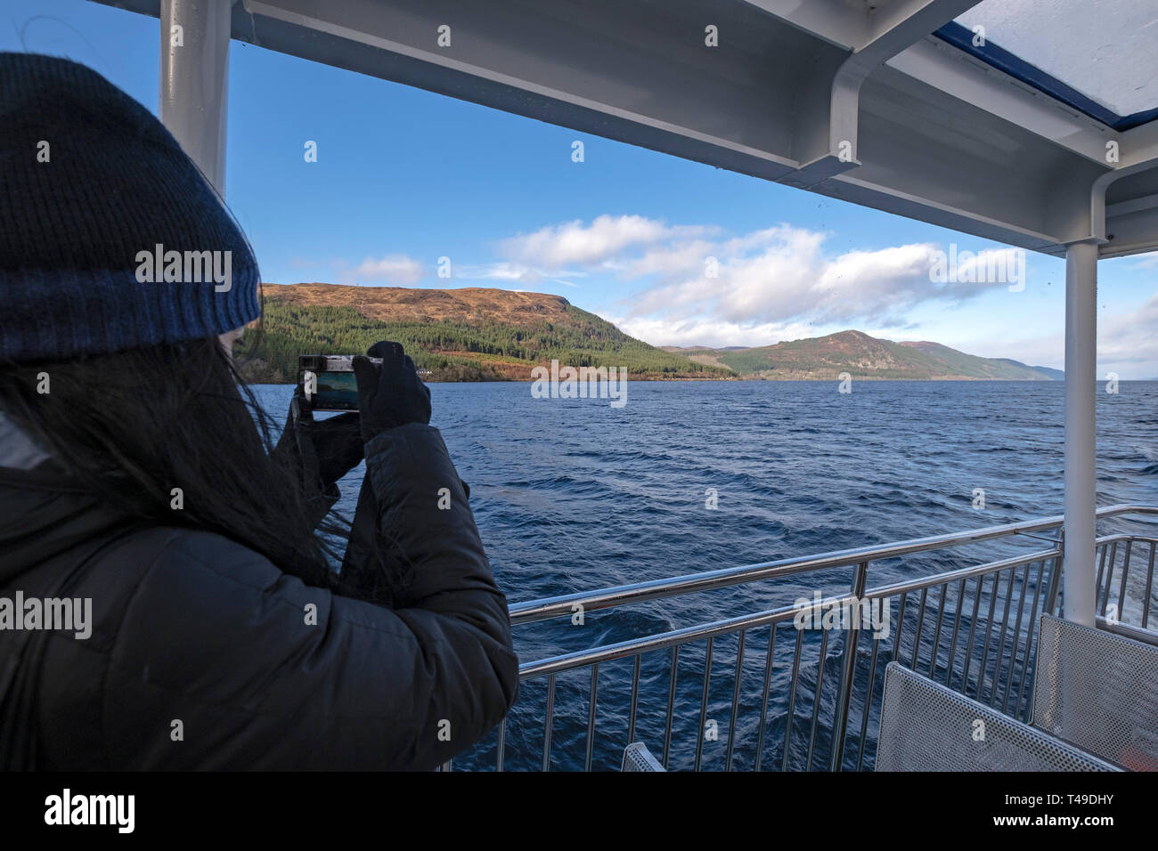 Tourist on a cruise boat tour of Loch Ness takes pictures in search of monster Nessie, Scottish Highlands, Scotland, UK, Europe Stock Photo