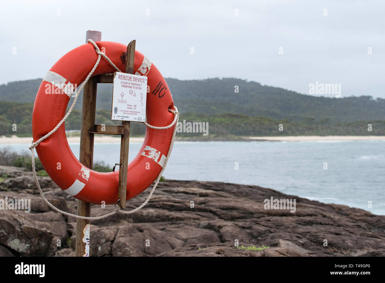 A life buoy or floatation device mounted near a popular rock fishing area at Kioloa Beach on the New South Wales south coast of Australia Stock Photo