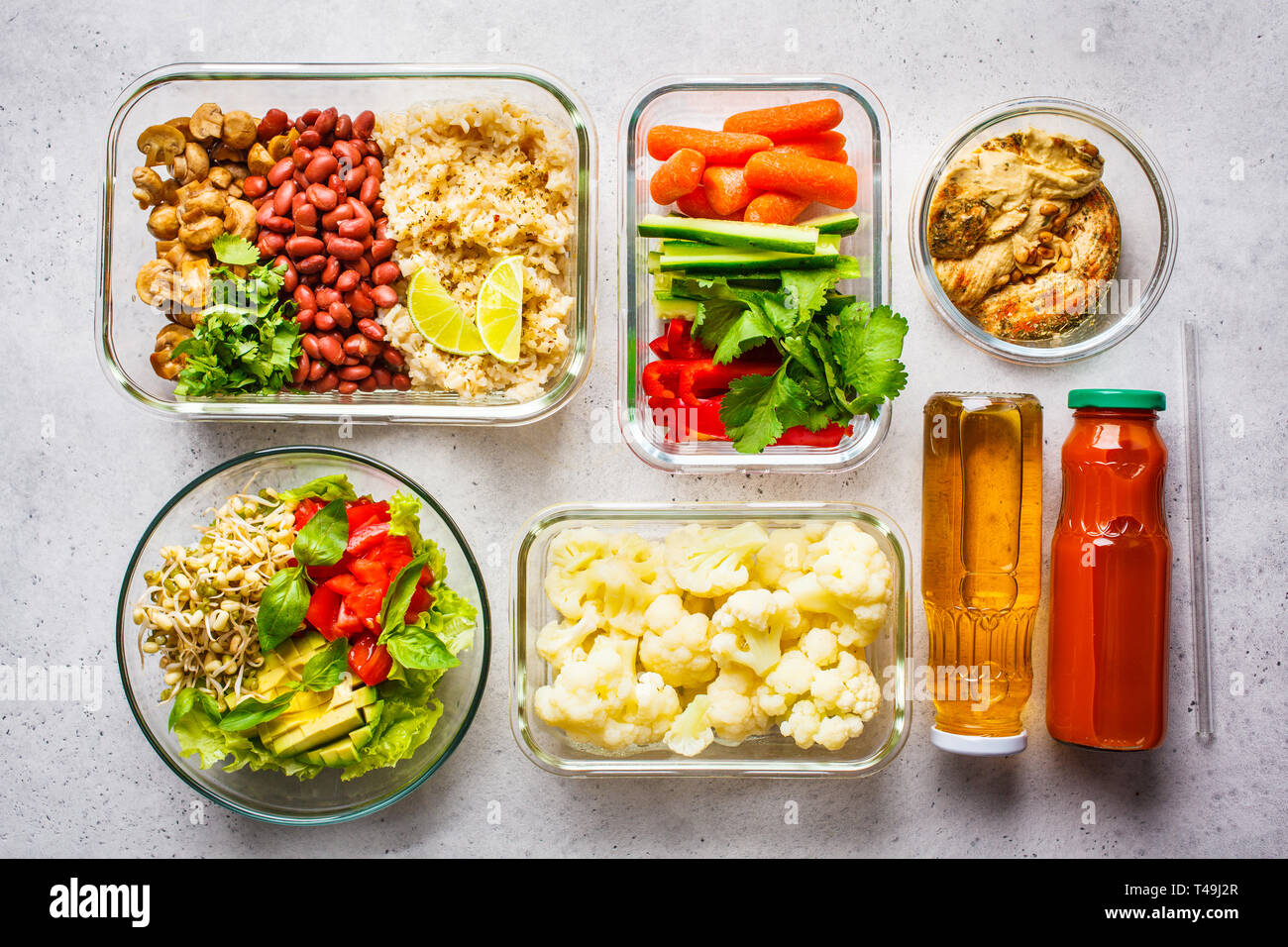 Healthy vegan food in glass containers, top view. Rice, beans, vegetables,  hummus and juice for take-away lunch Stock Photo - Alamy