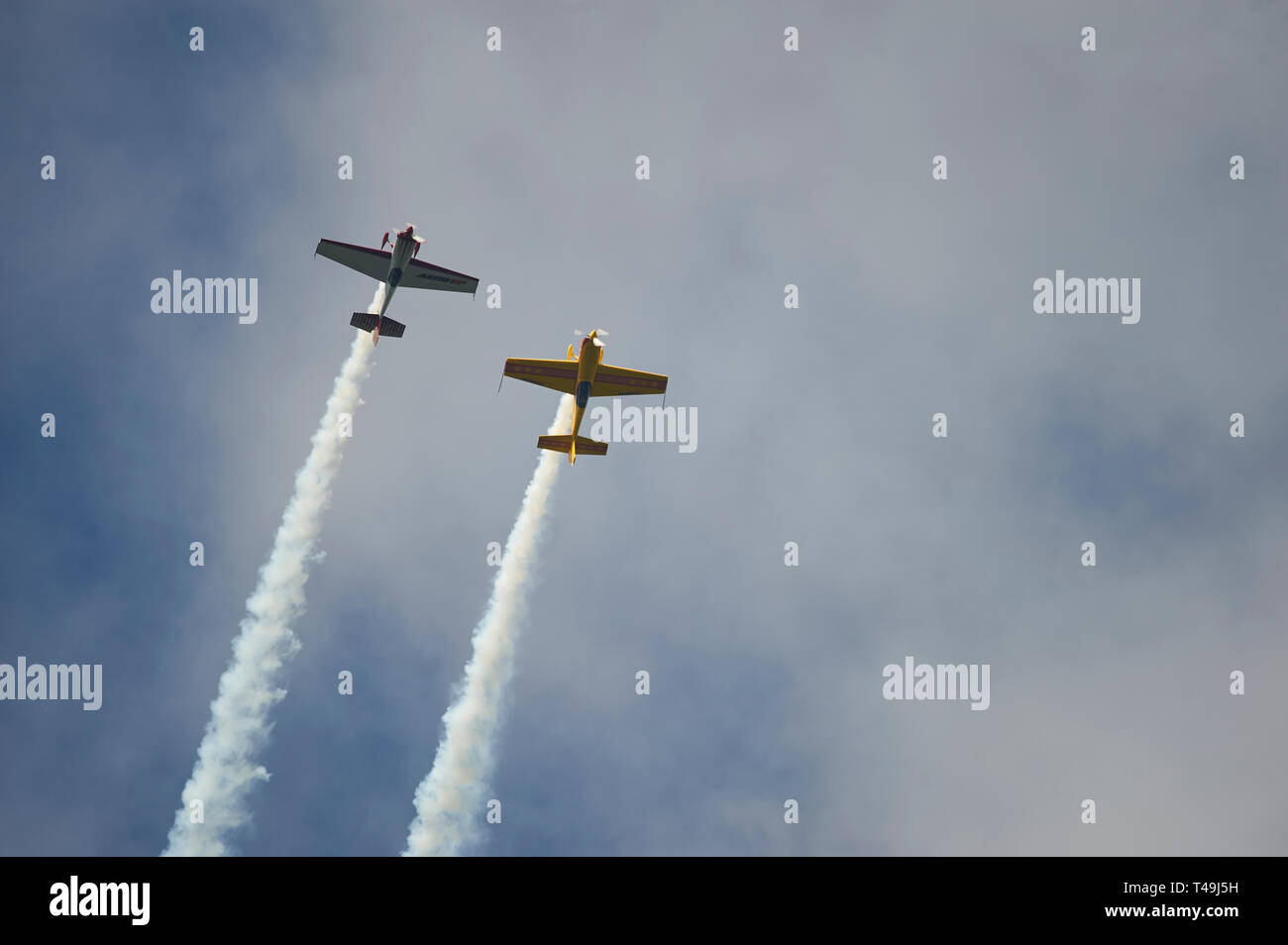 CAP 231 Stunt Aircraft during a display with smoke trails against a blue summer sky Stock Photo