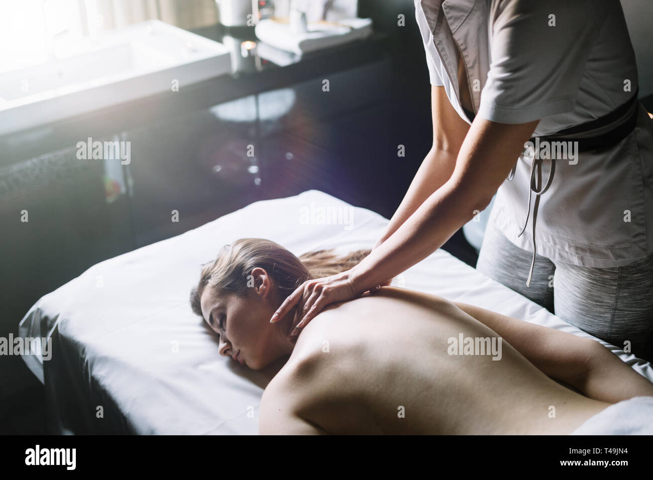 Masseur doing massage on woman body in the spa salon. Beauty treatment concept. Stock Photo