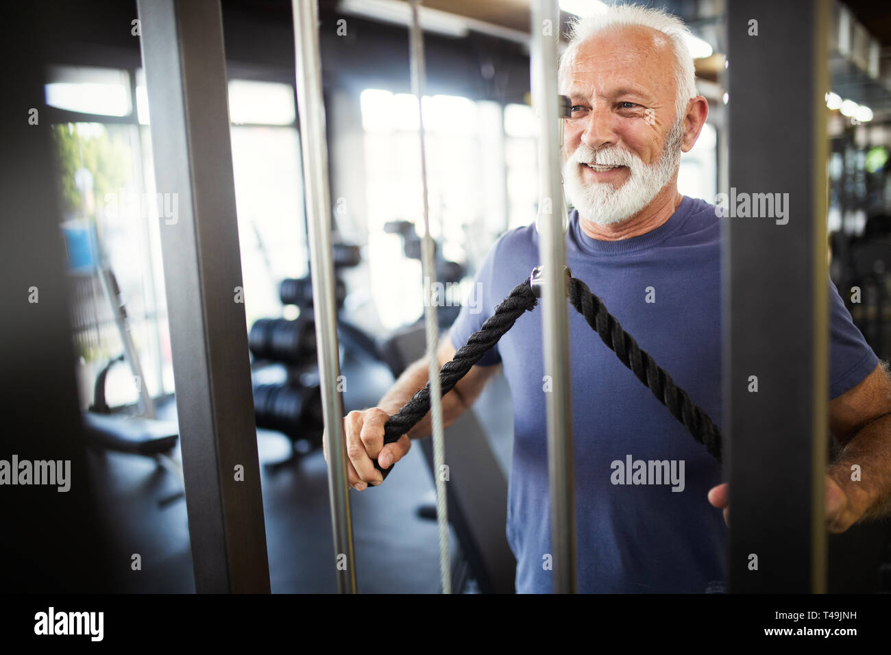 Happy fit mature man in gym working out to stay healthy Stock Photo