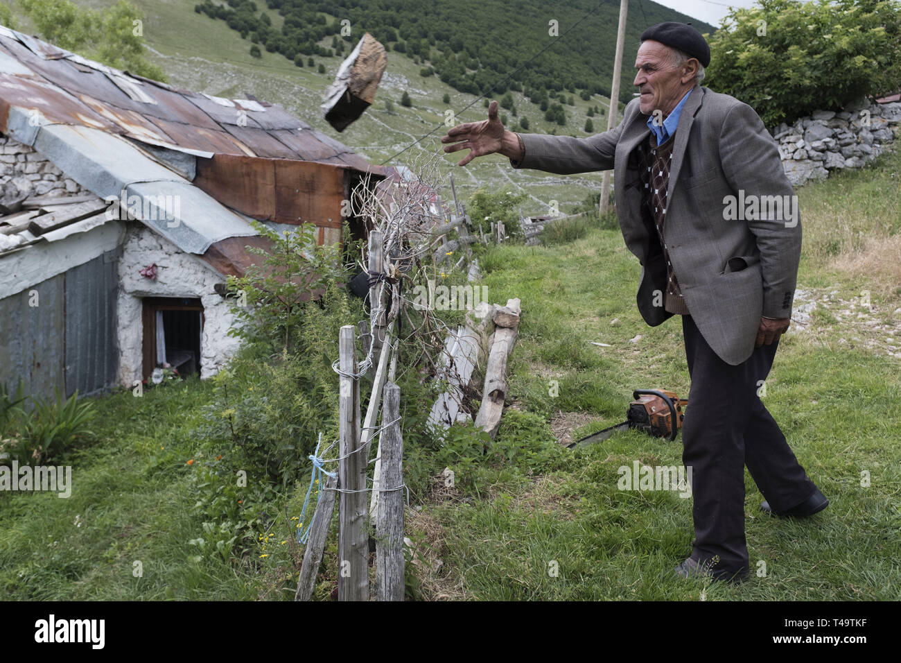 Lukomir, Bosnia. 9th July, 2018. A man throws wood that he just chopped for use in his stove. In the mountains above Sarajevo at about 1500 meters lies Lukomir, the most remote village in all of Bosnia. The village consists mainly of nomadic sheep herder, adn a population of abotu 20 people. Being deemed unstrategic by the Serbs, Lukomir is one of the only areas that remained untouched during the war of the 1990's. The population of the village is slowly disappearing. With children leaving to attend school elsewhere and not coming back, what is the future of this village? After this curre Stock Photo