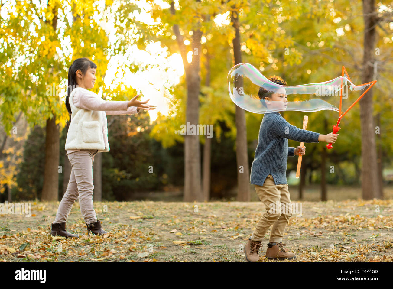 Two children playing with bubbles Stock Photo - Alamy