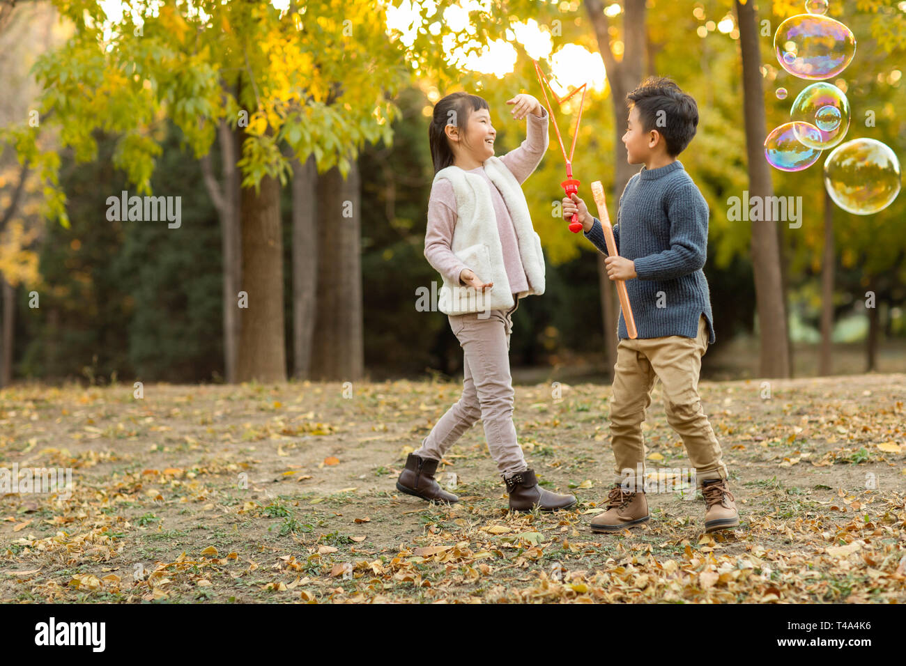 Two children playing with bubbles Stock Photo - Alamy