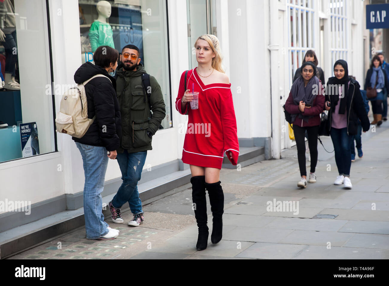 LONDON - FEBRUARY 17, 2019: The blonde girl in a red short dress goes on  the road Stock Photo - Alamy
