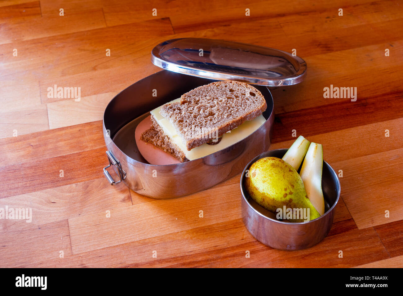 school lunch packed in stainless steel lunchbox on wooden surface Stock Photo