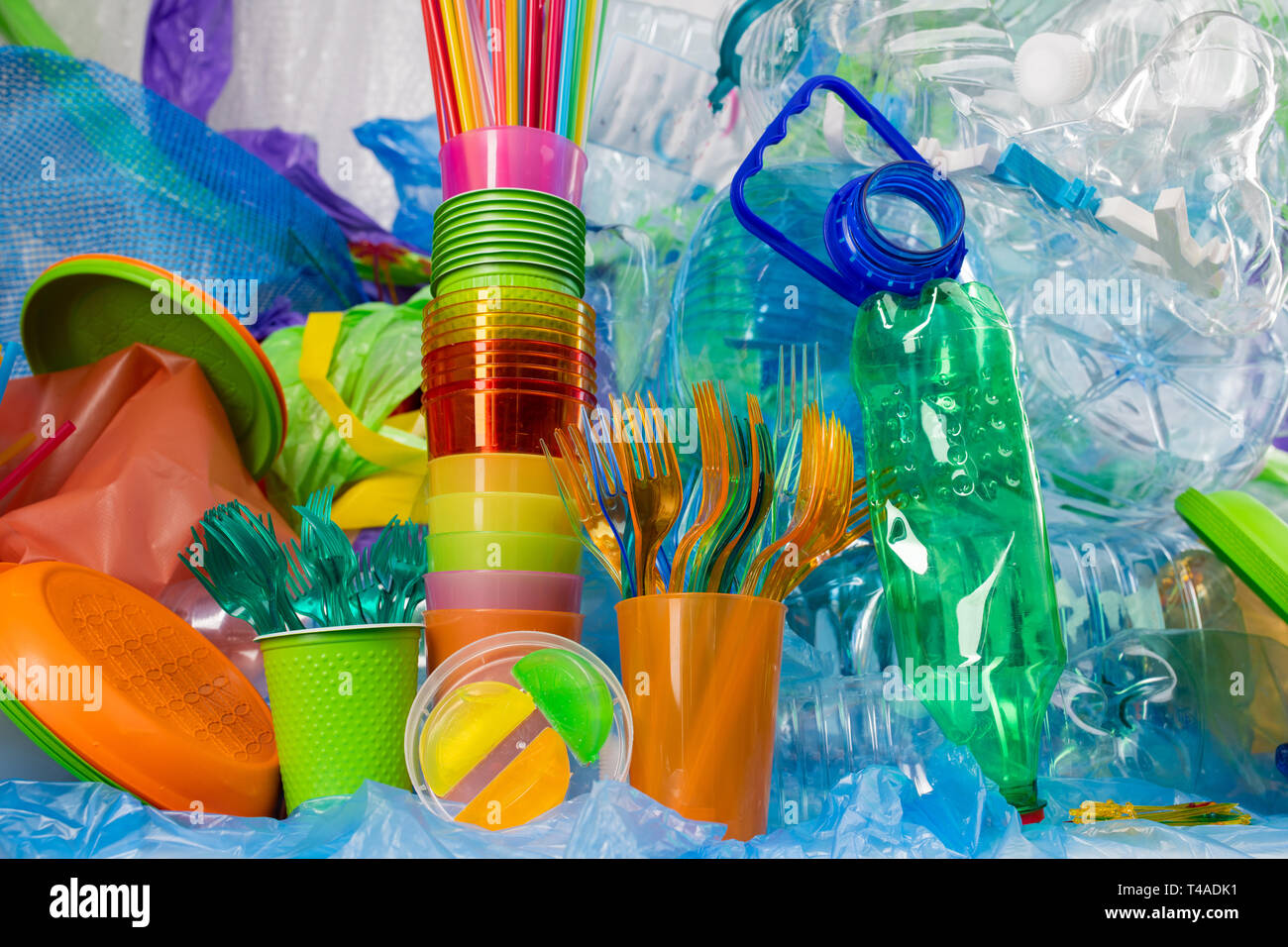 Transparent plastic forks standing in bright cup with funky straws nearby Stock Photo