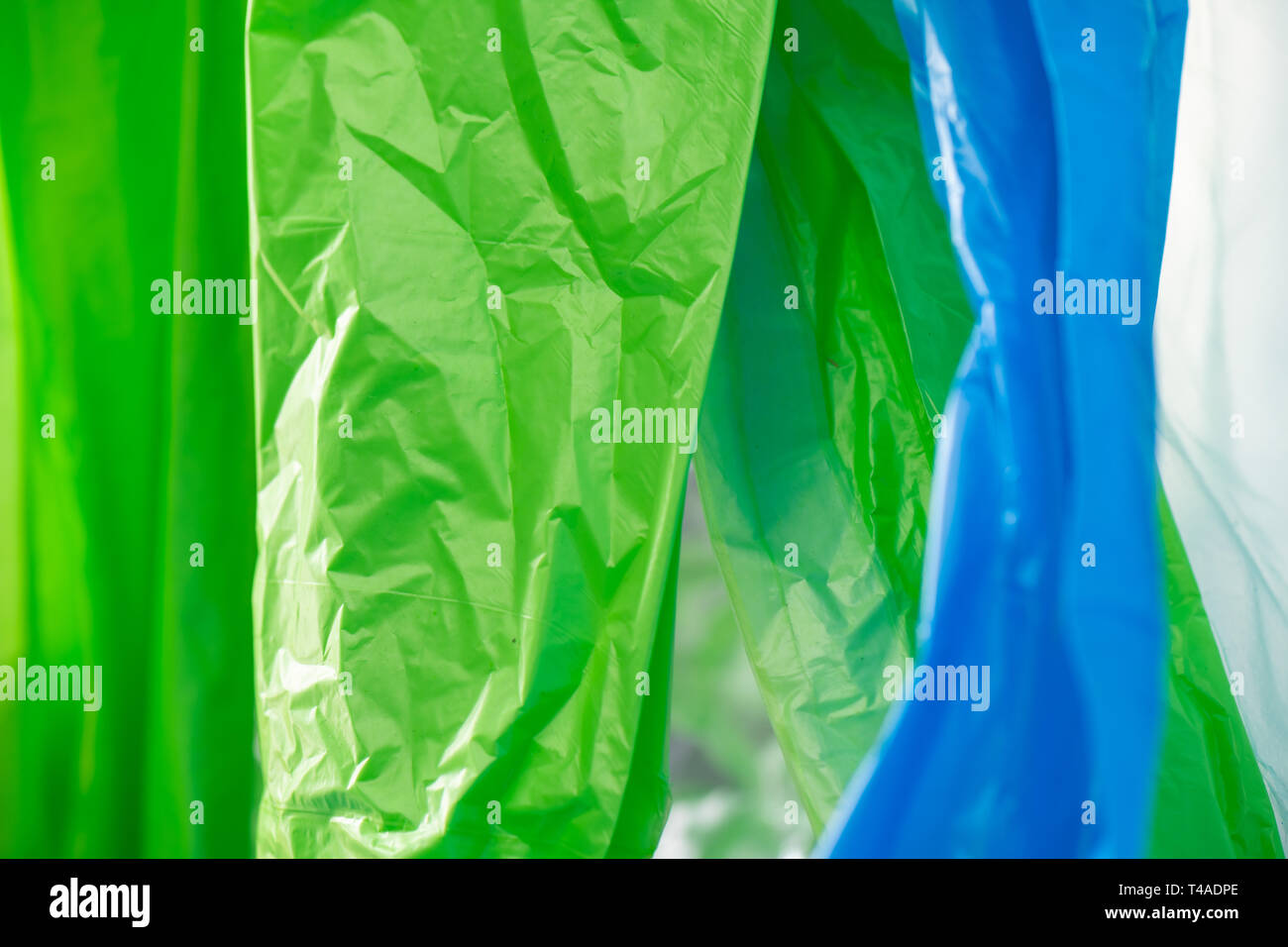 Light green and blue plastic trash bags polluting environment Stock Photo