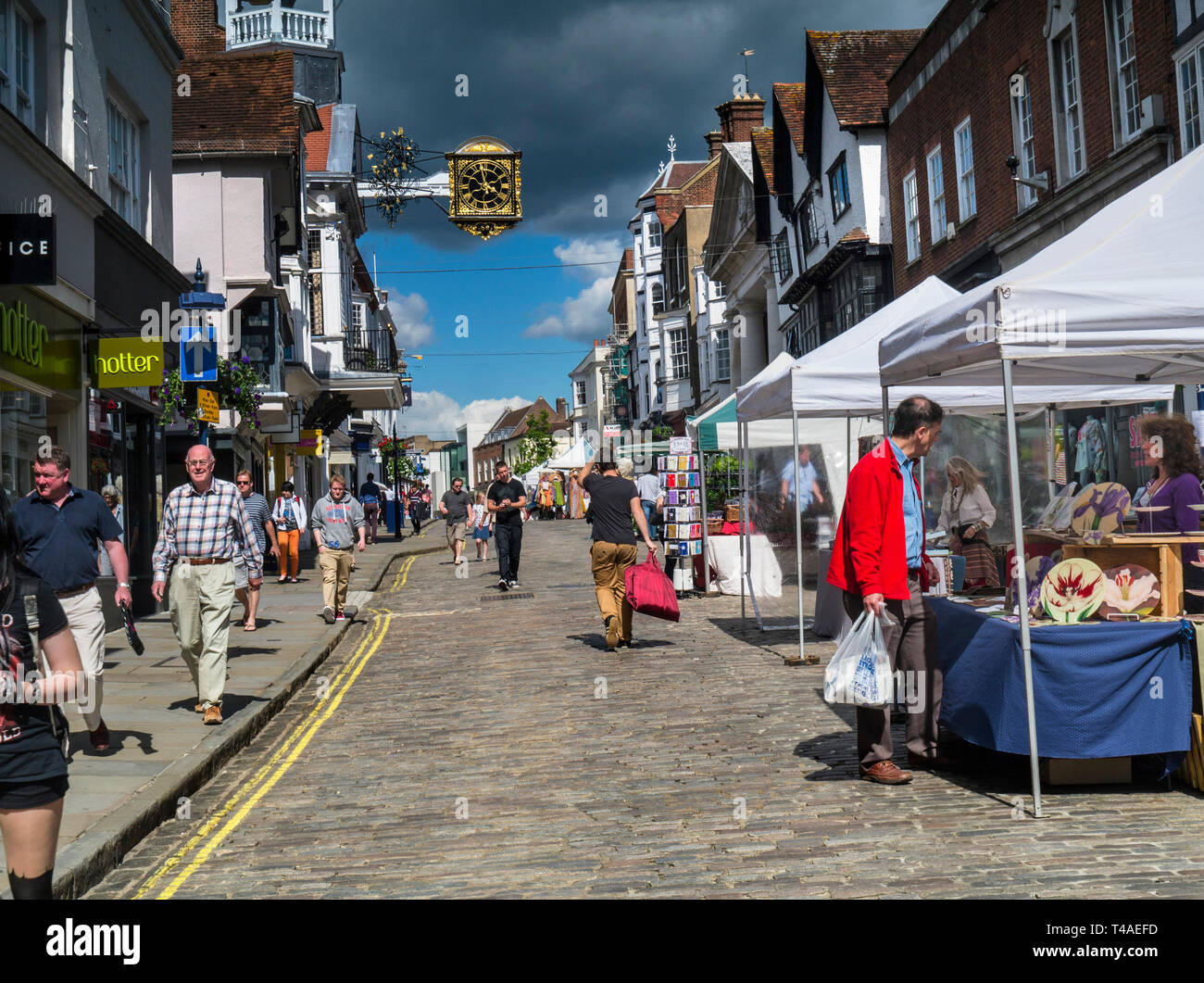 Guildford Historic High Street market, historic clock and shoppers, with summer local arts and crafts market day stalls Guildford Surrey UK Stock Photo