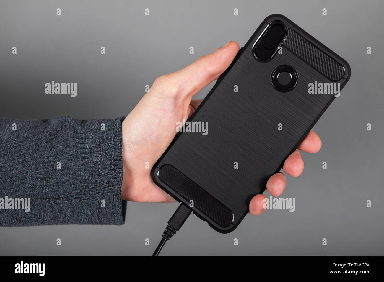 Mans hand holding black mobile phone Stock Photo