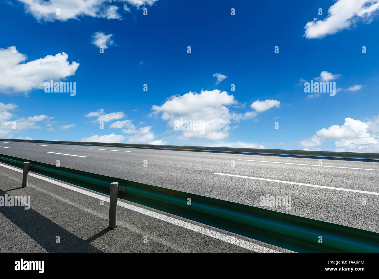 Asphalt road and blue sky with white clouds scene Stock Photo - Alamy