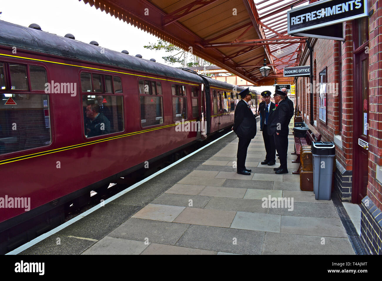 Staff in uniform chat on the platform at Broadway Station before the 11