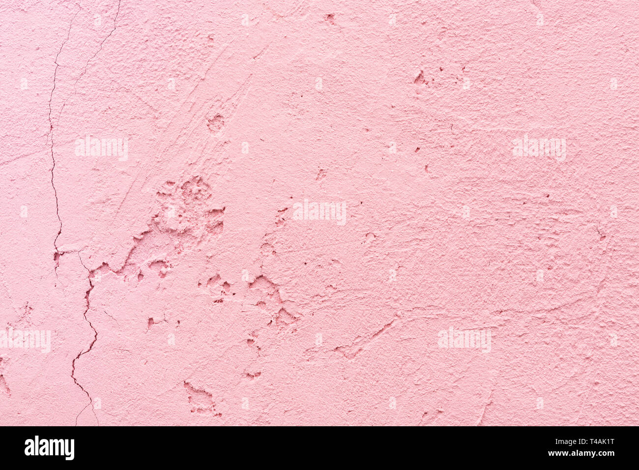 Cracked texture of plaster wall. Pink stucco close-up. Abstract background, interior decor. Stock Photo