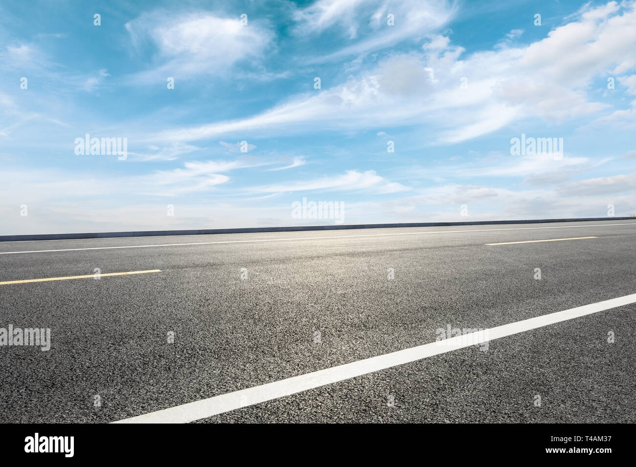 Empty asphalt road and blue sky with white clouds scene Stock Photo - Alamy