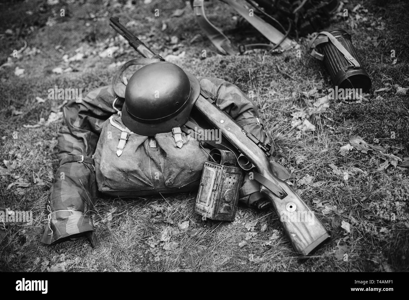 World War II German Wehrmacht Soldier Ammunition Of World War II On Ground.  WWII Military Helmet, Lights, Rifle Mauser Karabiner 98K. Photo In Black  Stock Photo