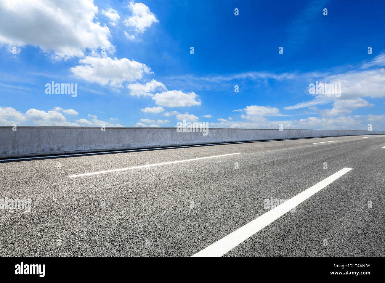 Empty asphalt road and blue sky with white clouds scene Stock Photo - Alamy