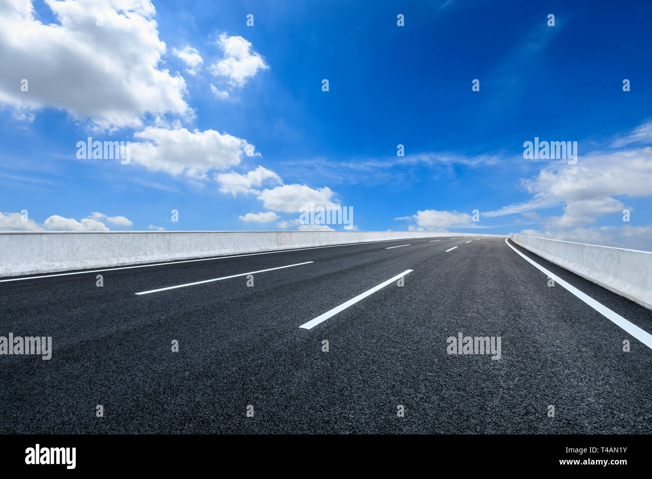 Empty asphalt road and blue sky with white clouds scene Stock Photo - Alamy
