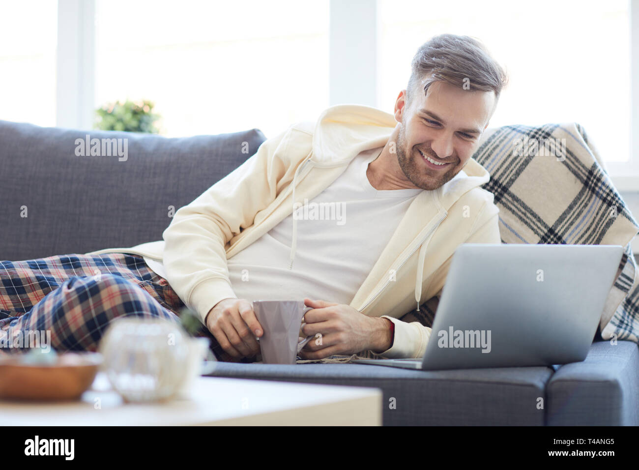 Young Man Lying on Sofa Stock Photo