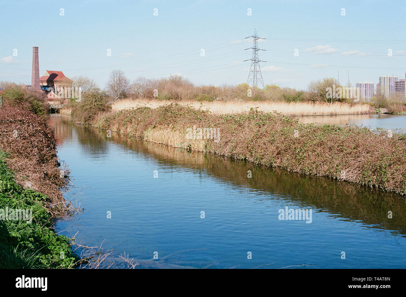 Coppermill Stream on Walthamstow Wetlands, North East London UK, with the Victorian Engine House building and chimney in background Stock Photo
