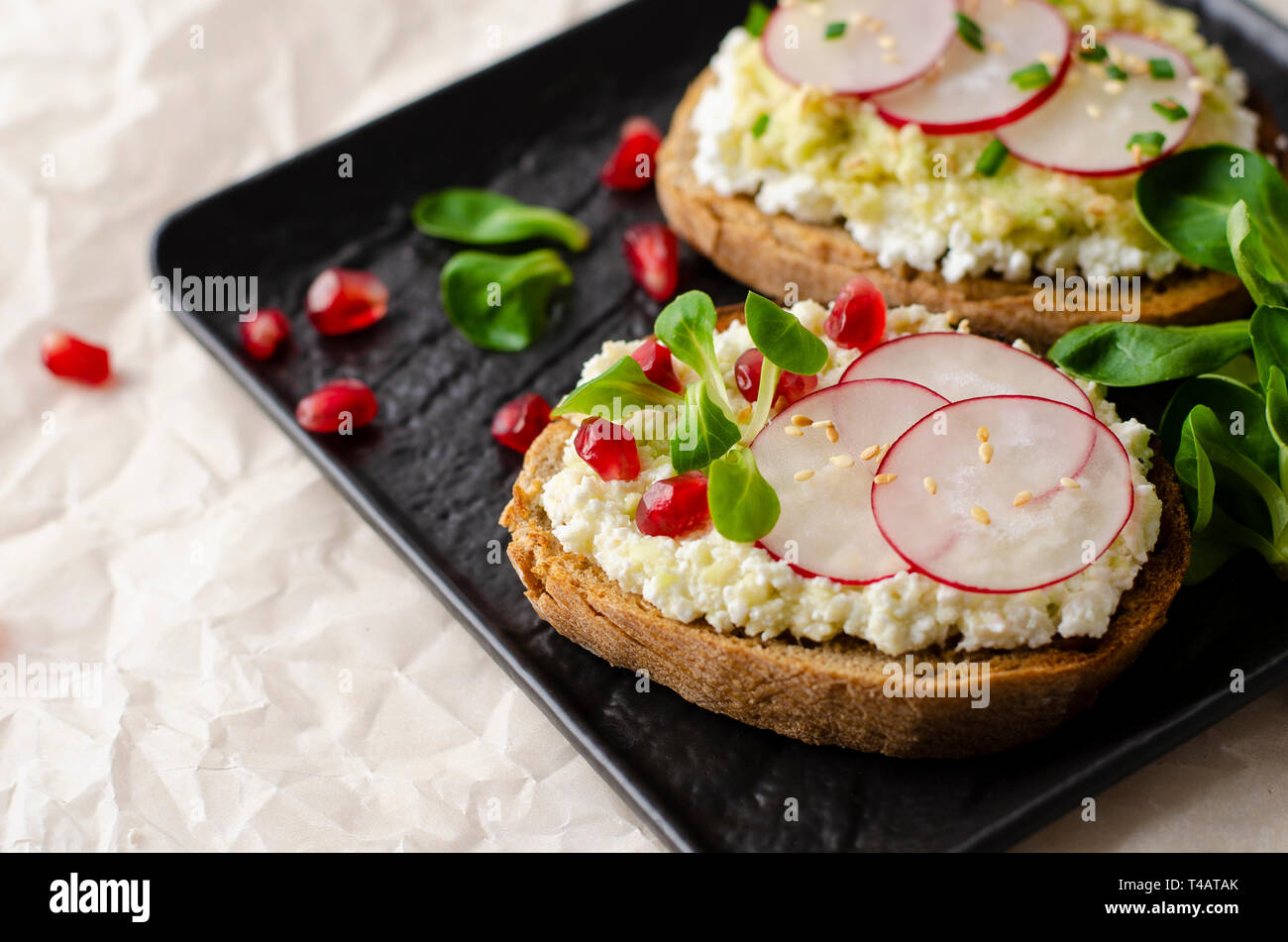 Toasts with cottage cheese and smashed avocado, radish, corn salad