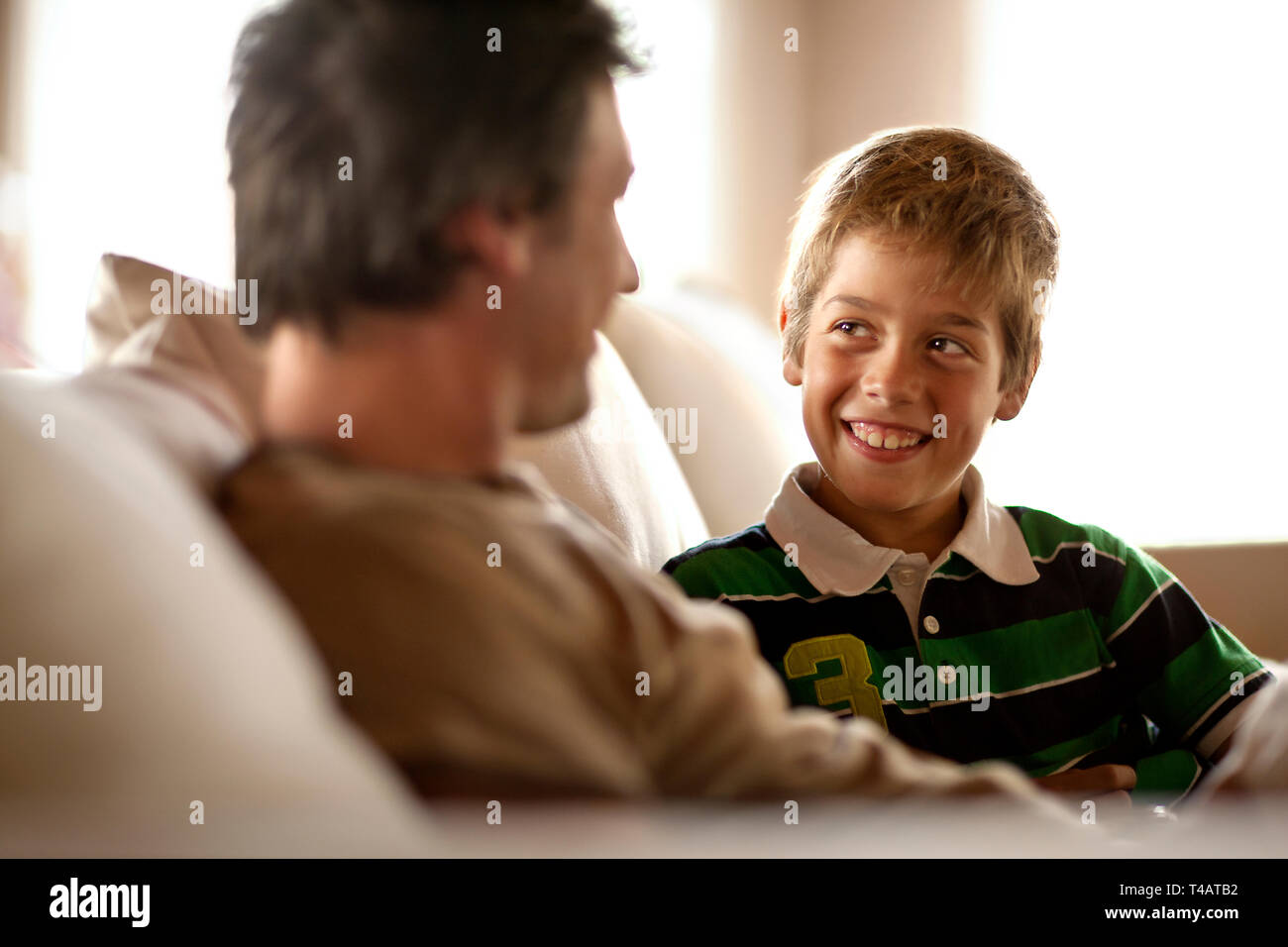Father and son sitting on sofa together Stock Photo - Alamy